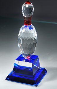 Our Crystal Bowling Pin Trophy features a bowling pin made of solid, clear crystal with red accents at the neck & top of the pin. It's mounted on a clear crystal base with a blue reflective bottom to give the trophy a clear, blue & red look to it. The base includes an engraving plate for personalization, but this photo does not show that. This bowling trophy stands 10" tall, weighs over 5.5 lbs & comes in a satin-lined deluxe gift box. 