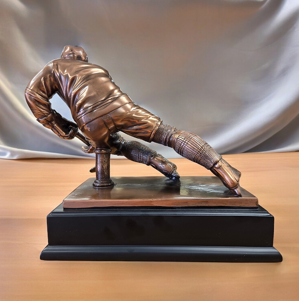 Our Hockey Trophy RFB023 shown from behind. It's a bronze resin hockey player with a hockey stick mounted on a black base.