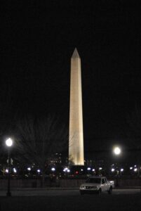 A photo of The Washington Monument take at night as it is lighted from it's base and can be seen from a long way away.