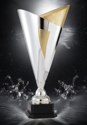 Our Victory Trophy cup features a contemporary V-Shaped cup made from mostly silver chrome metal with a gold metal mesh accent on the top right. It's mounted on a black wood base that includes an engraving plate for personalization. This DTC99 is 8" wide and 28" tall. The contemporary trophy cup in this photo is placed in a black background with a white light & water being splashed.